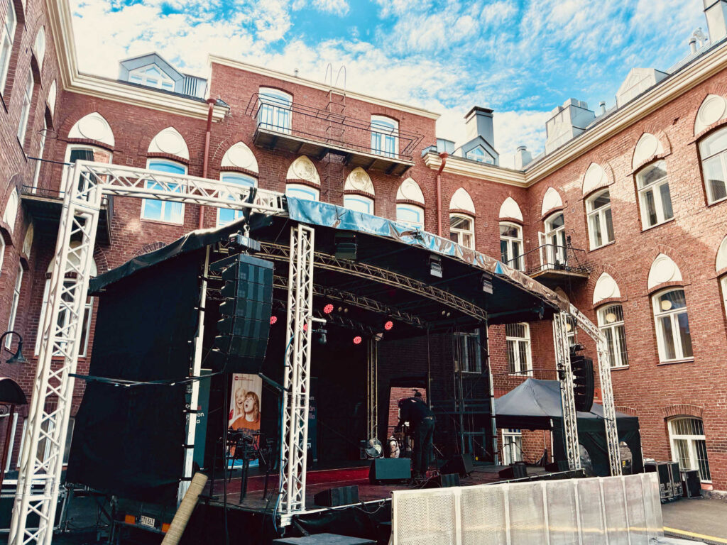 Sateelta suojattu ulkoilmalavan tekniikka festivaalilla - vesitiivis katosrakenne suojaa äänentoistolaitteita